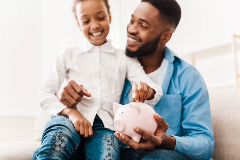 Man and child with piggy bank